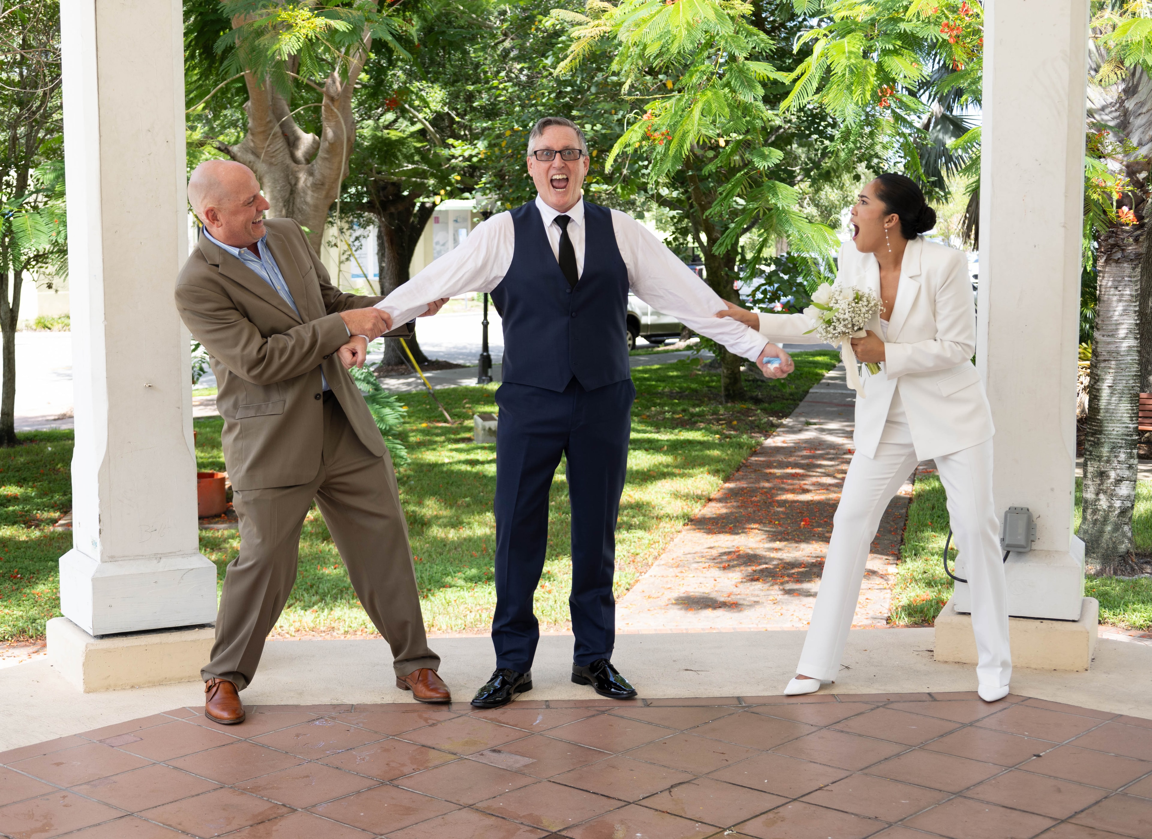 Wedding party laughing together under gazebo