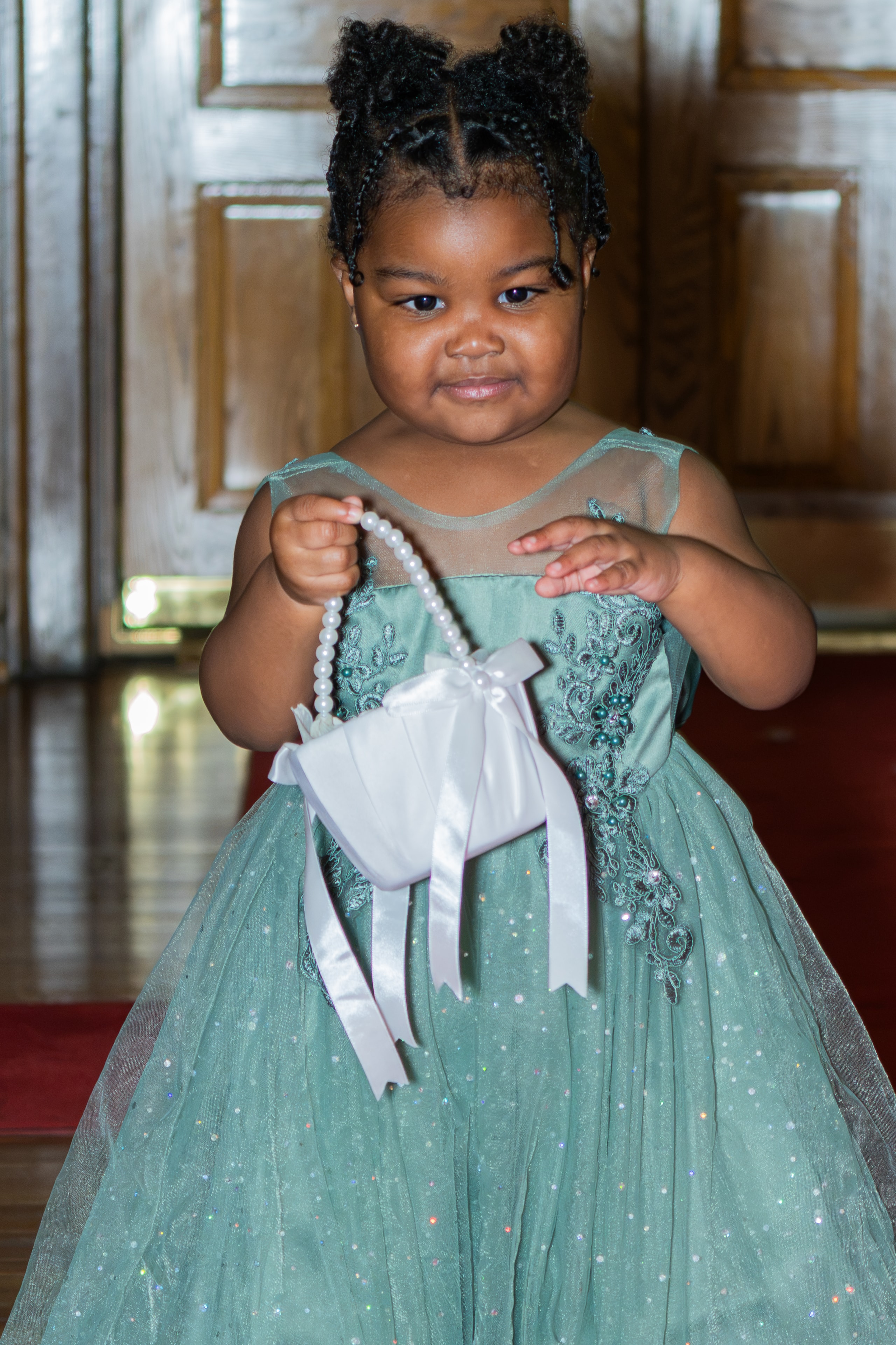Flower girl in green dress with pearl purse