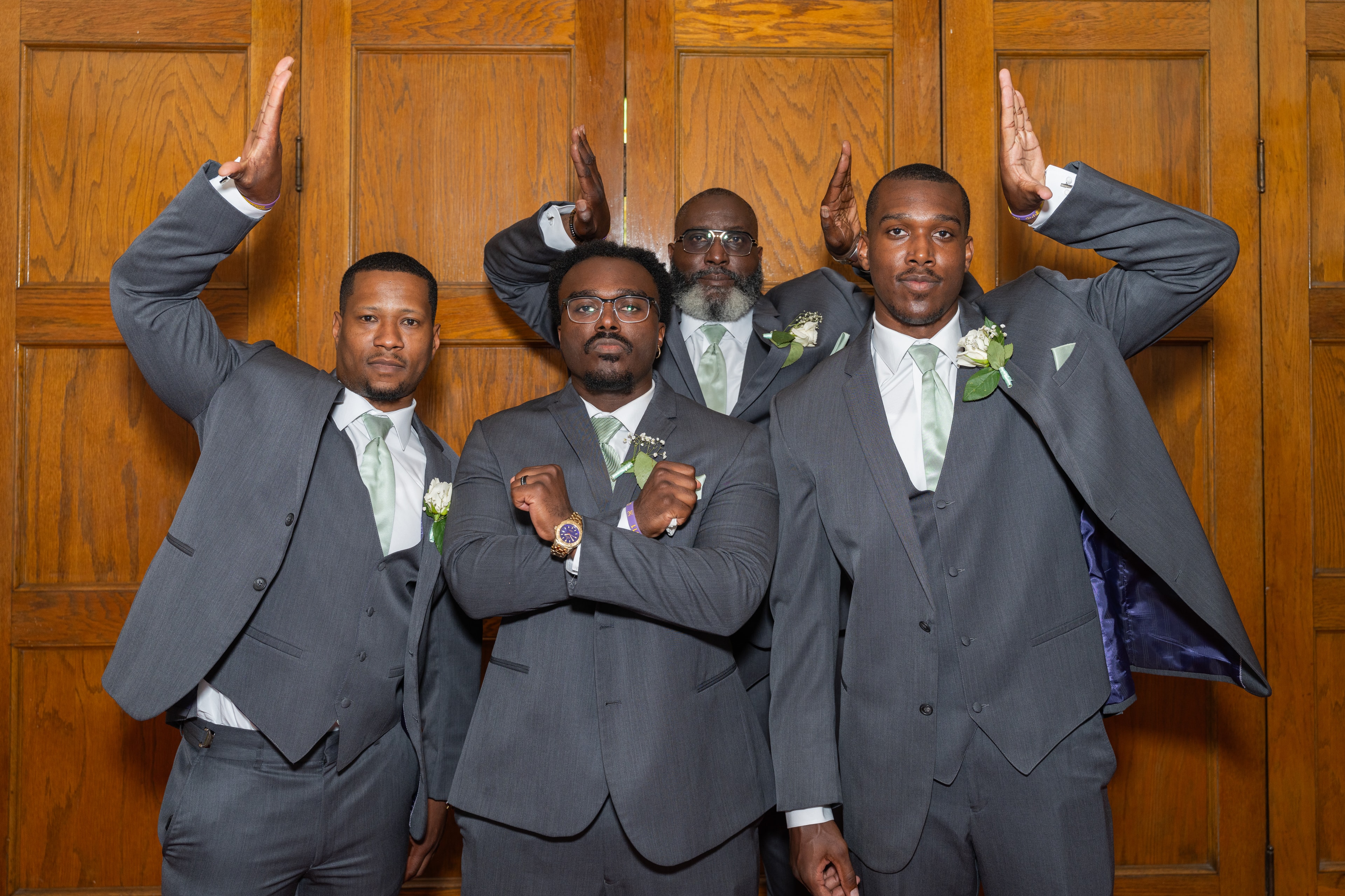 Groomsmen playful pose against wood paneling