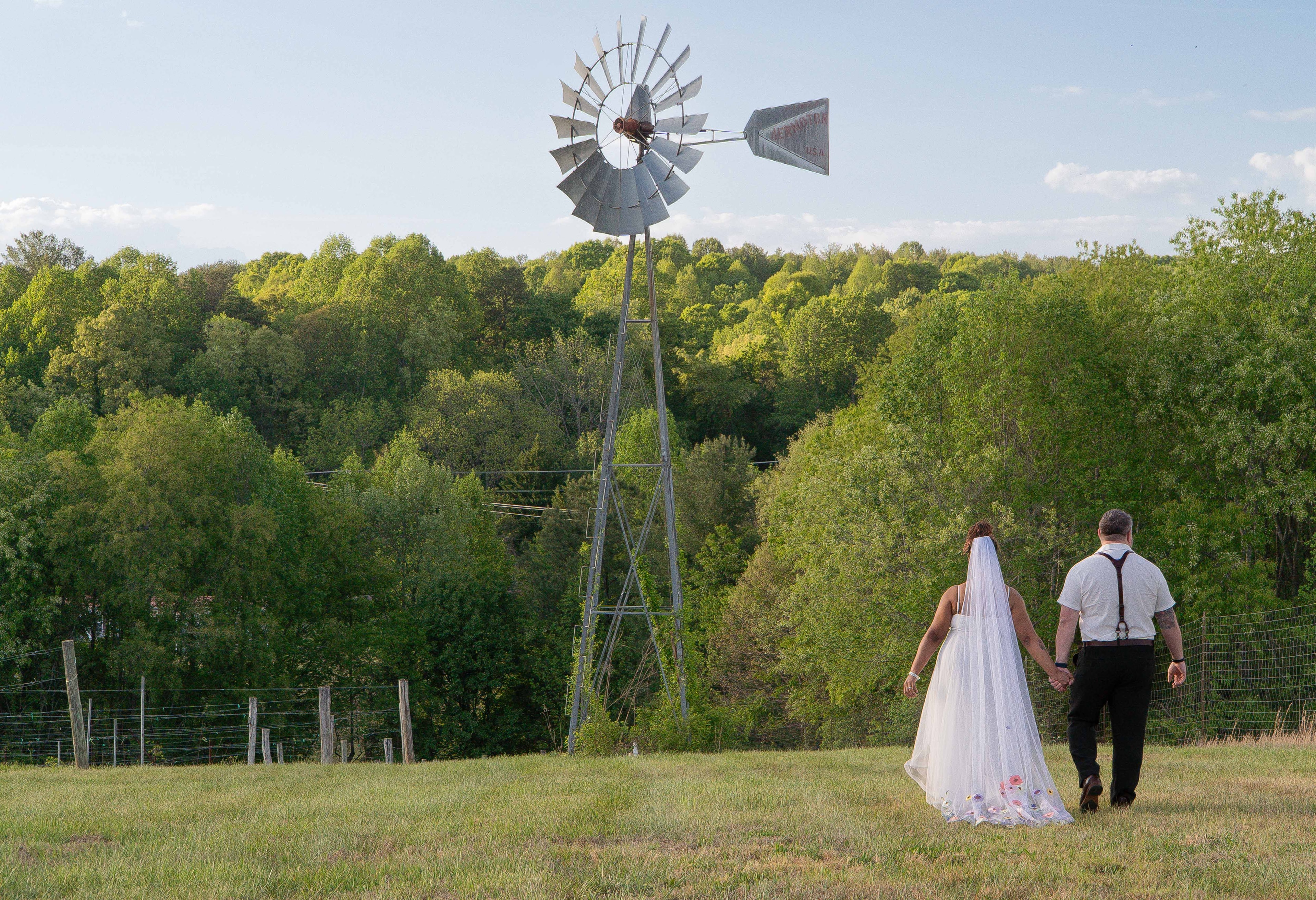 Couple walking hand in hand toward windmill