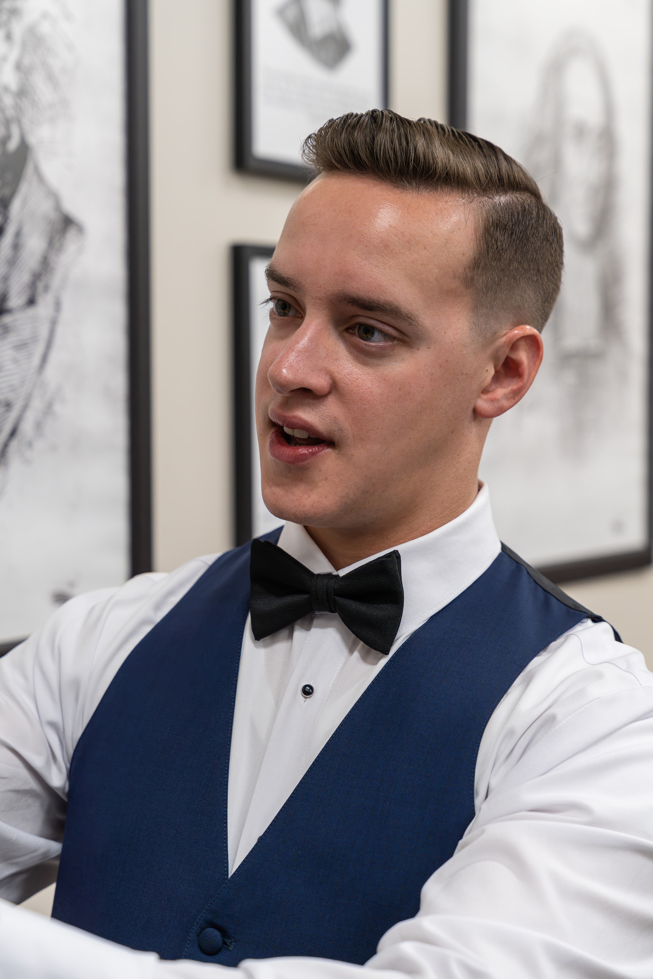 Groom in navy vest and bow tie getting ready before the ceremony